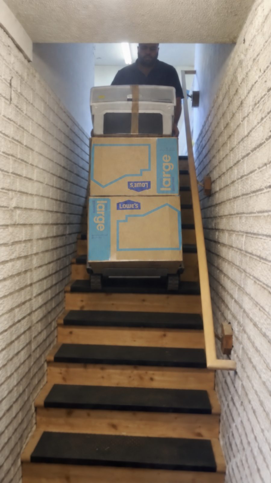 MVP Logistics crew moving stacked boxes down stairs